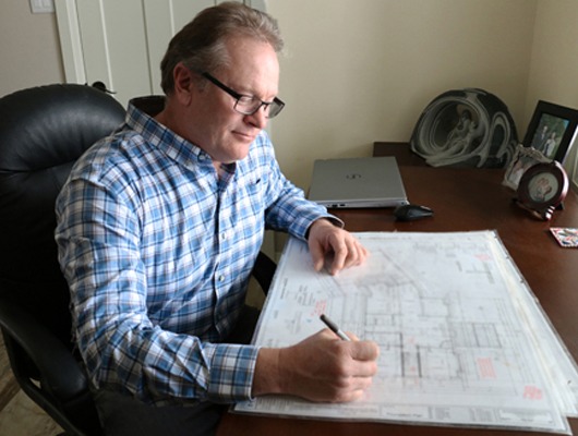 a man sitting at a desk writing on a piece of paper