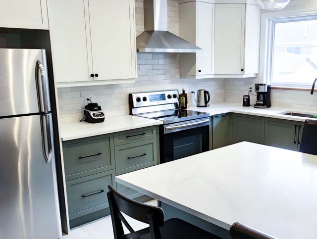 a kitchen with a refrigerator, stove, sink, and table